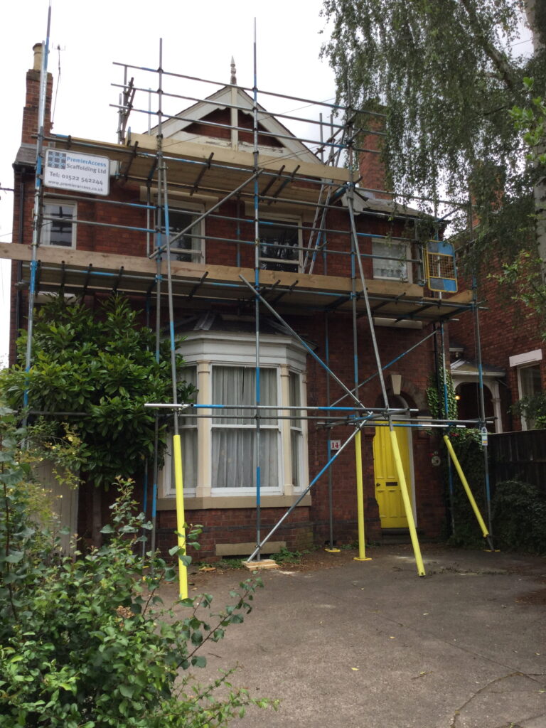 scaffolding on the front of a house undergoing work