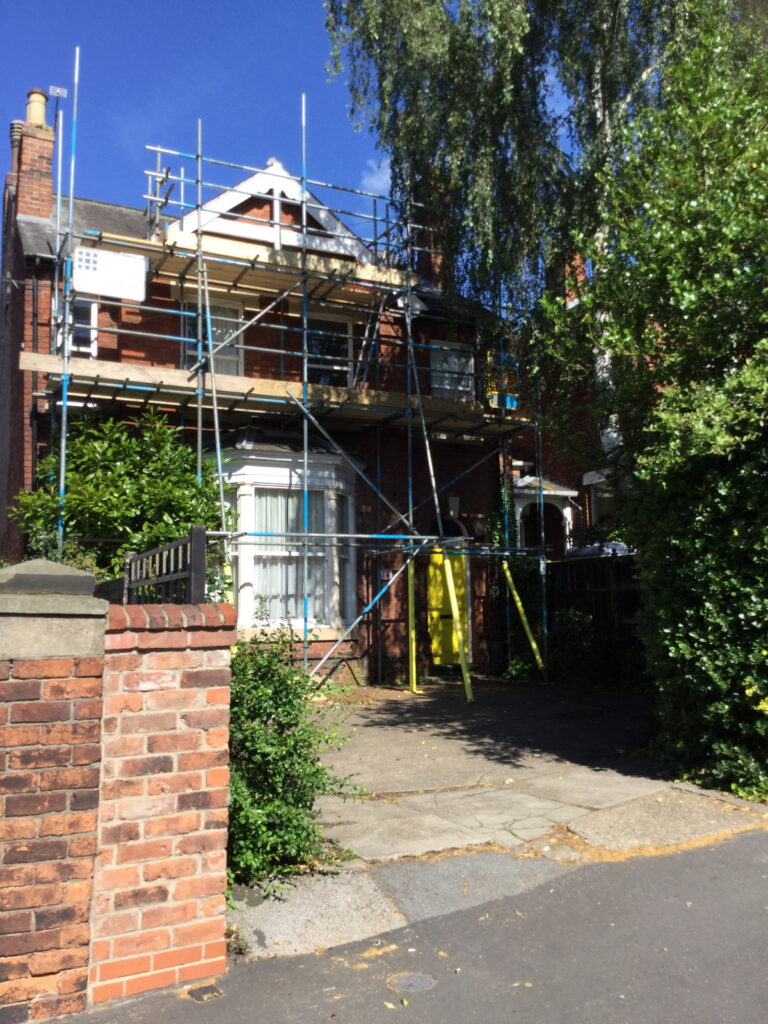 scaffolding on the front of a house undergoing work - image 3