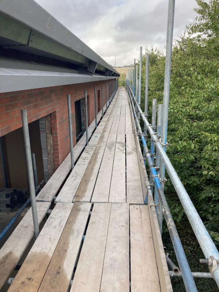 a large amount of scaffolding along the top of a building under construction