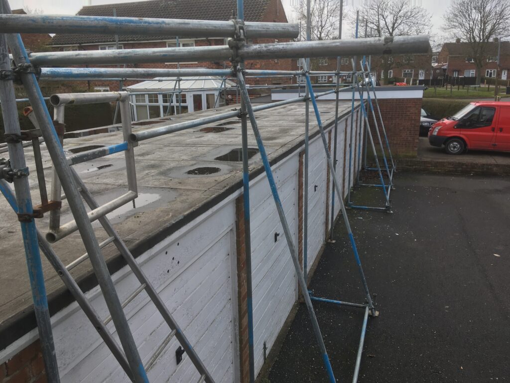 scaffolding on surrounding a block of garages for roof work - image 2