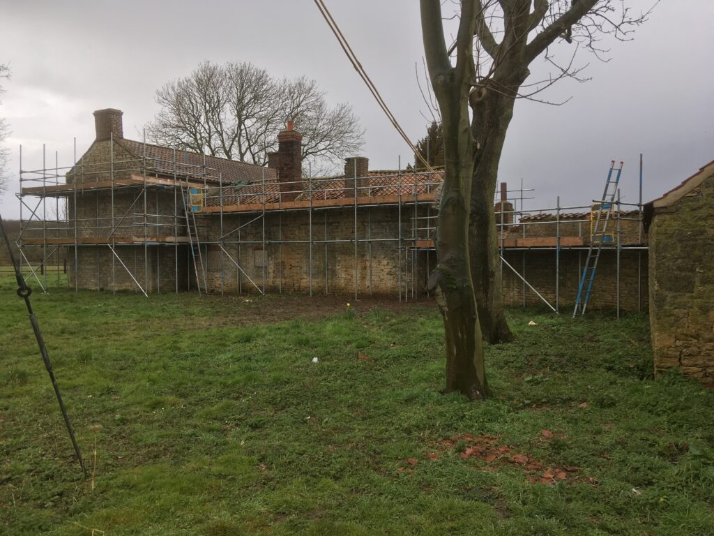 scaffolding surrounding an old farm house - image 3