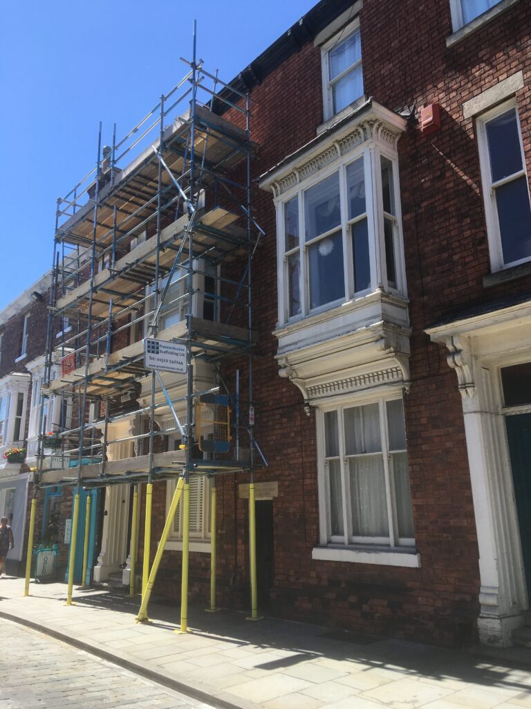 scaffolding on the front of terraced house with pavement underneath - image 2