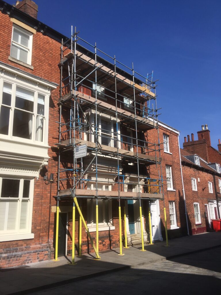 scaffolding equipment on front of terraced house going over pavement - image 2