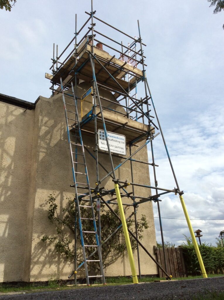 scaffold tower on side of cottage by road - image 3