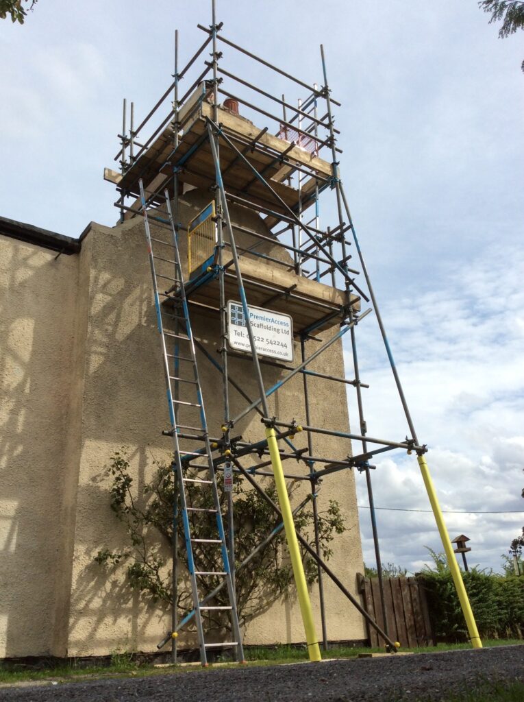 scaffold tower on side of cottage by road - image 5