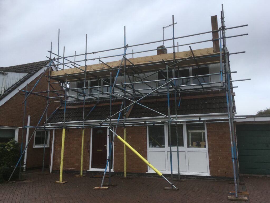 scaffolding covering the front of a house for roof access