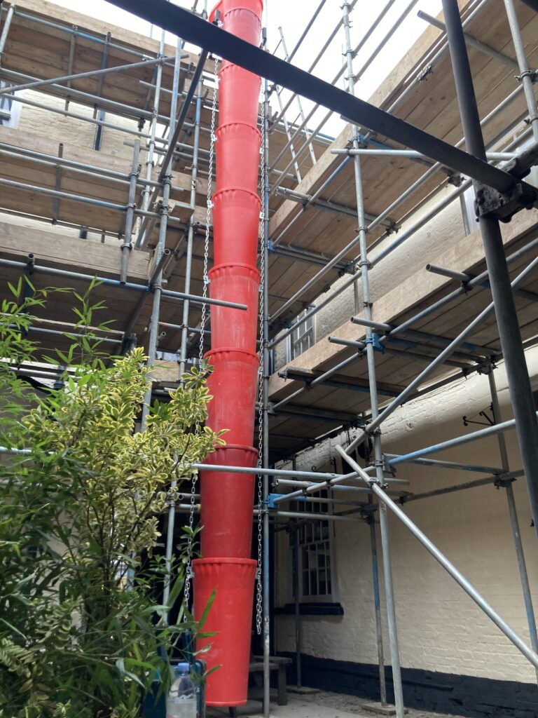 large amount of scaffolding with red rubble tube at The Bull Hotel in Horncastle