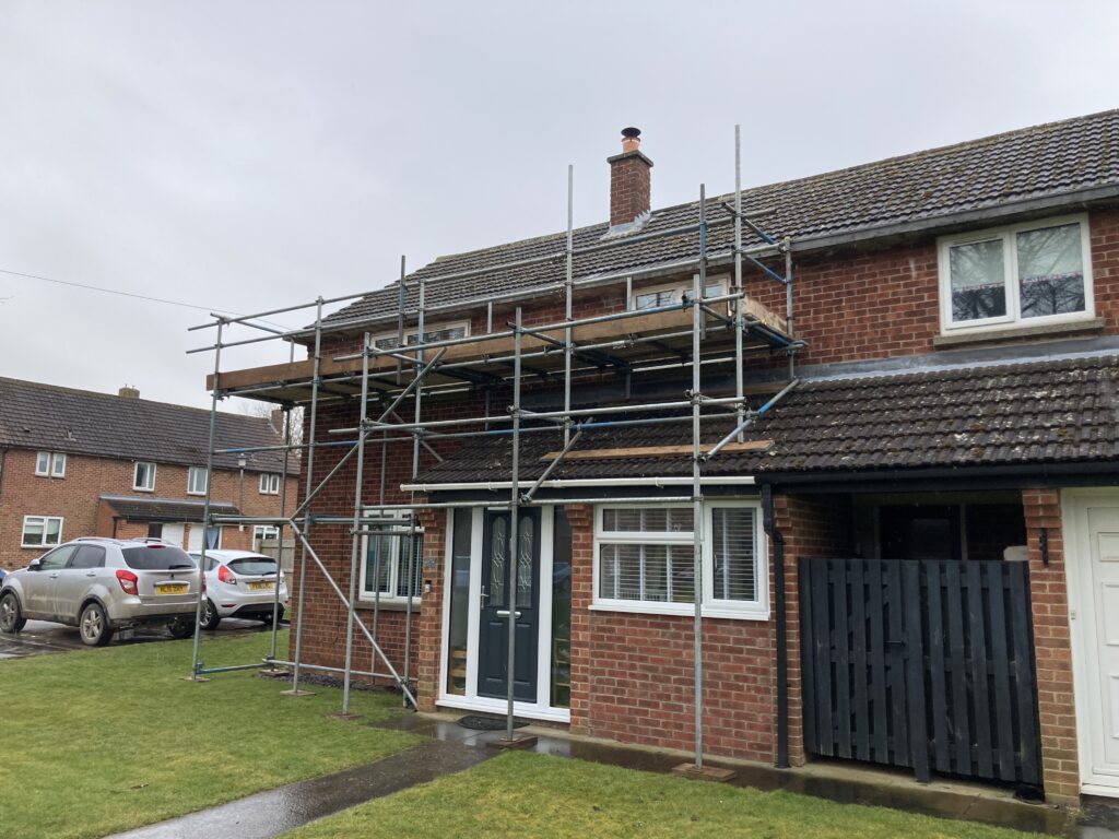 scaffolding on the front of a small terraced house