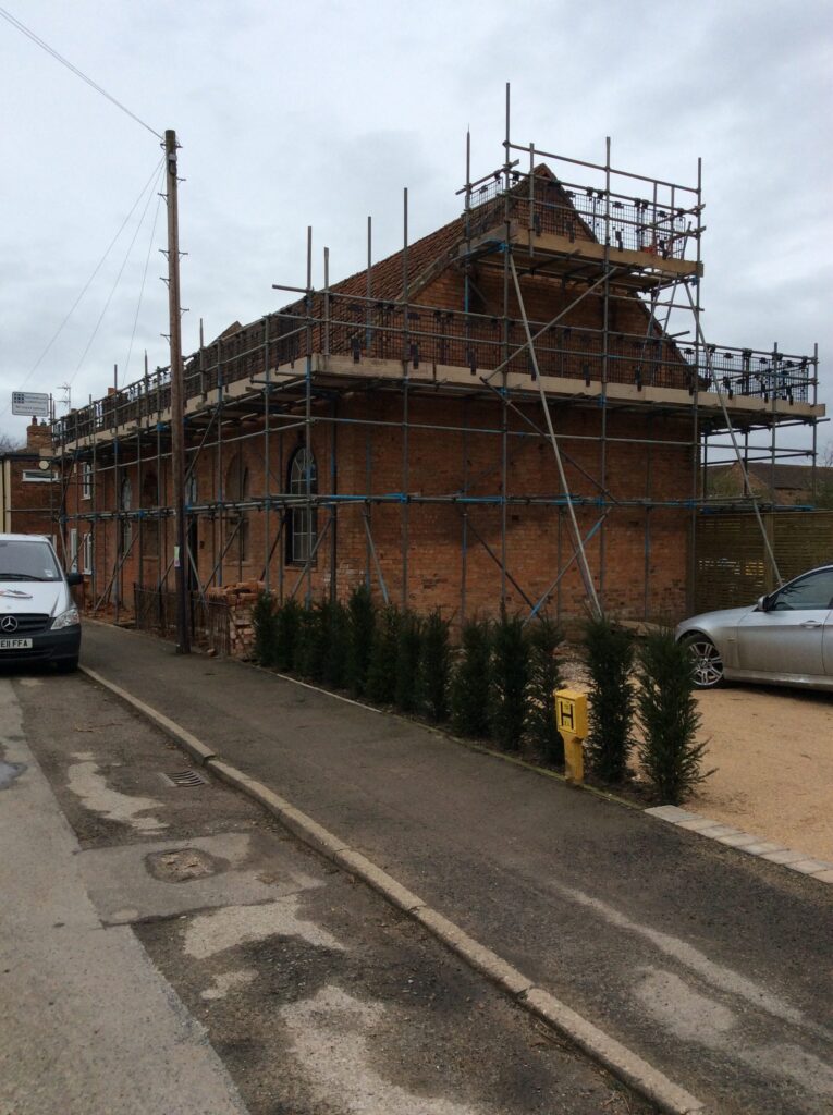 scaffolding surround the roof of a building for safe access - image 2