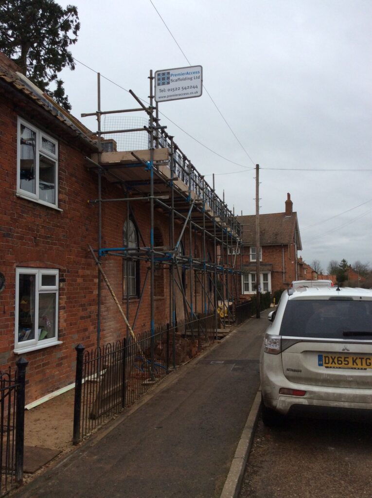 scaffolding surround the roof of a building for safe access