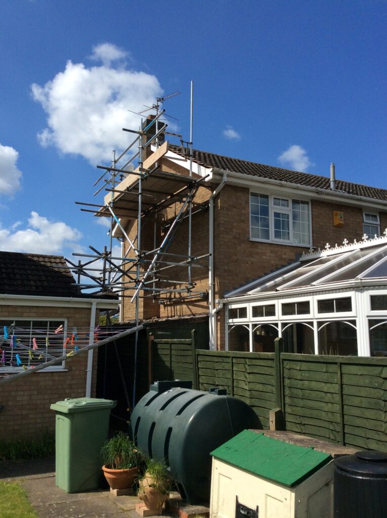 scaffolding on the side of a house with conservatory