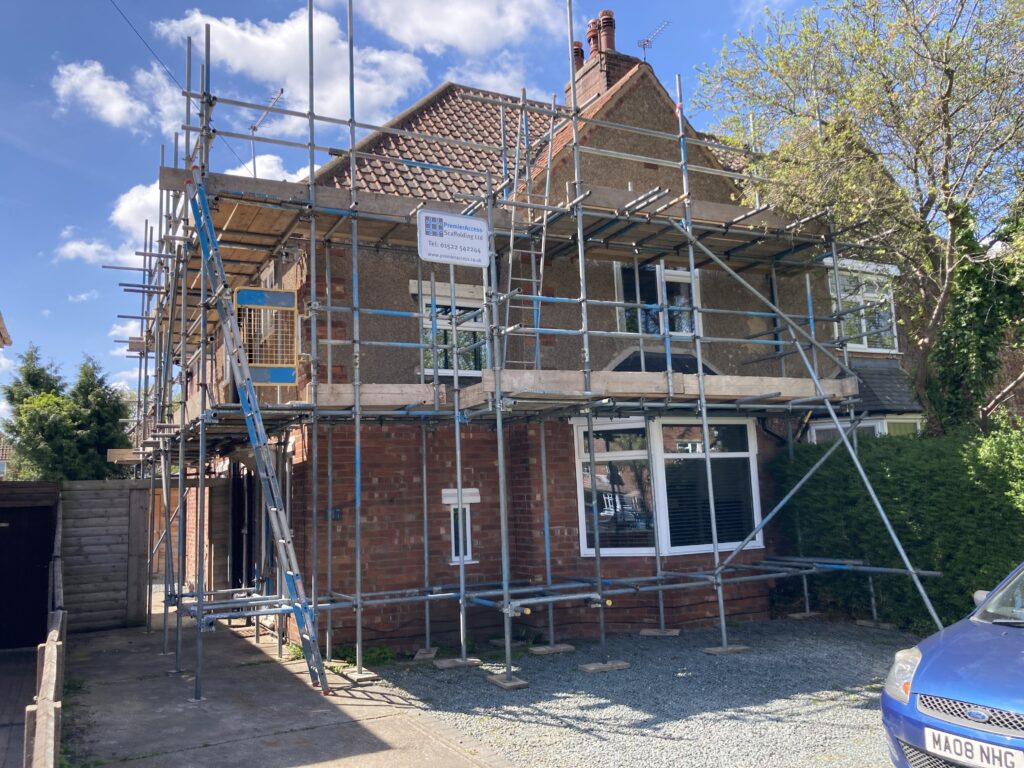 two story house surrounded by scaffolding