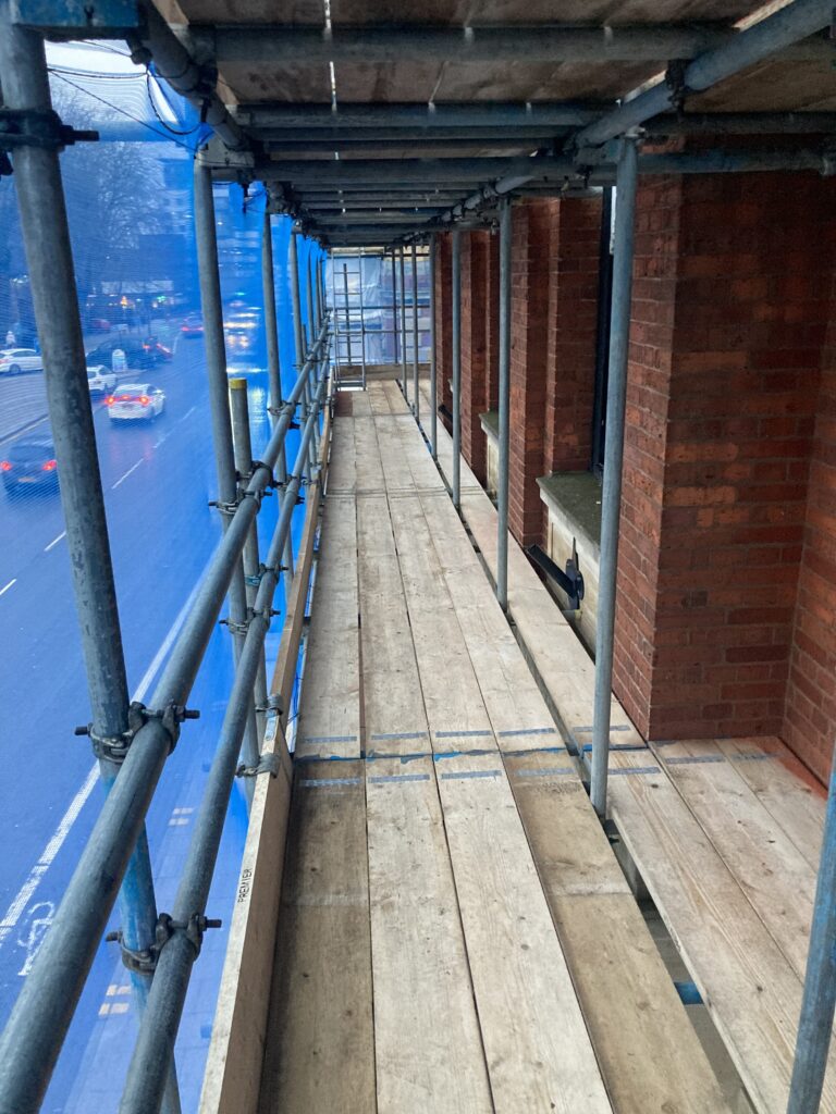 scaffolding on a building by a busy road in Lincoln