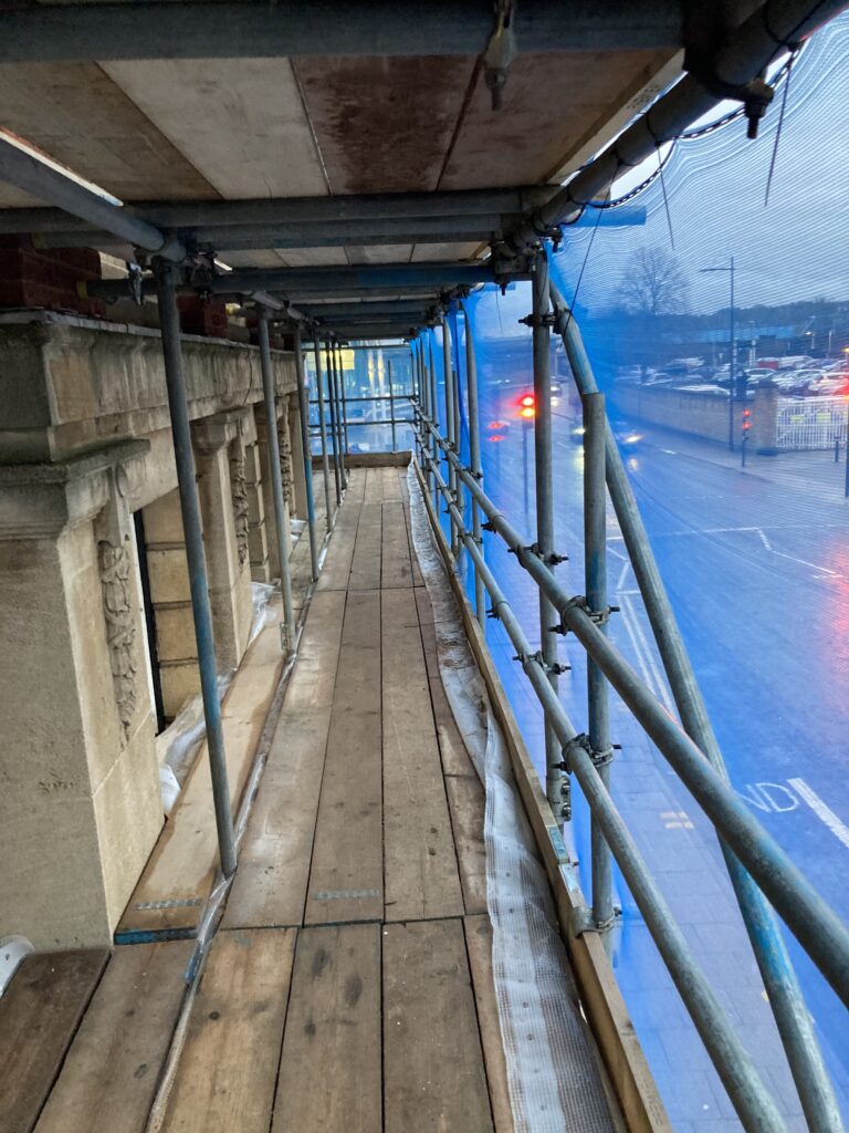 scaffolding on a building by a busy road in Lincoln