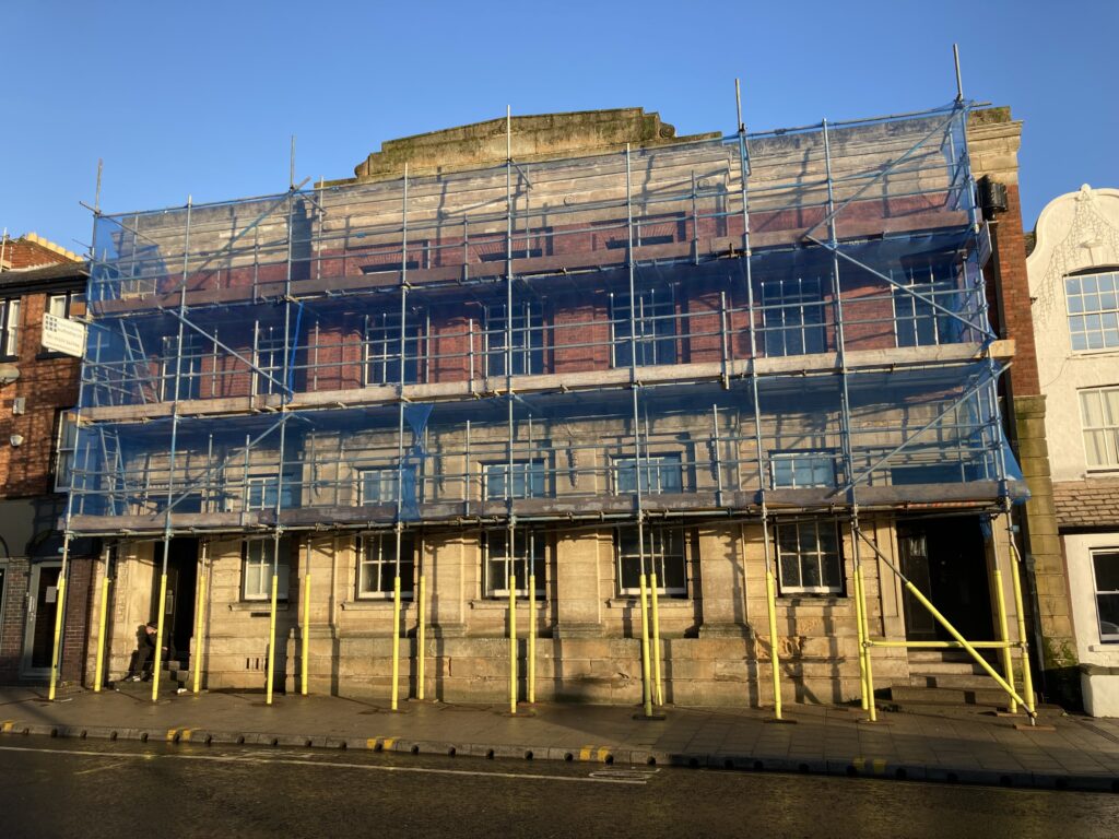 scaffolding on a building by a busy road in Lincoln