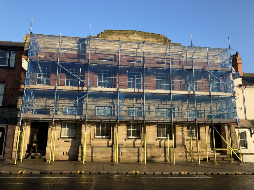 scaffolding on a building by a busy road in Lincoln
