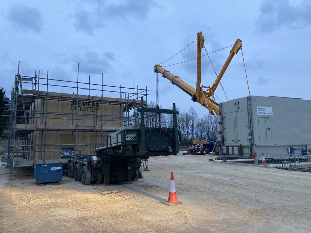 scaffolding surrounding a covered gas compressor on a construction site