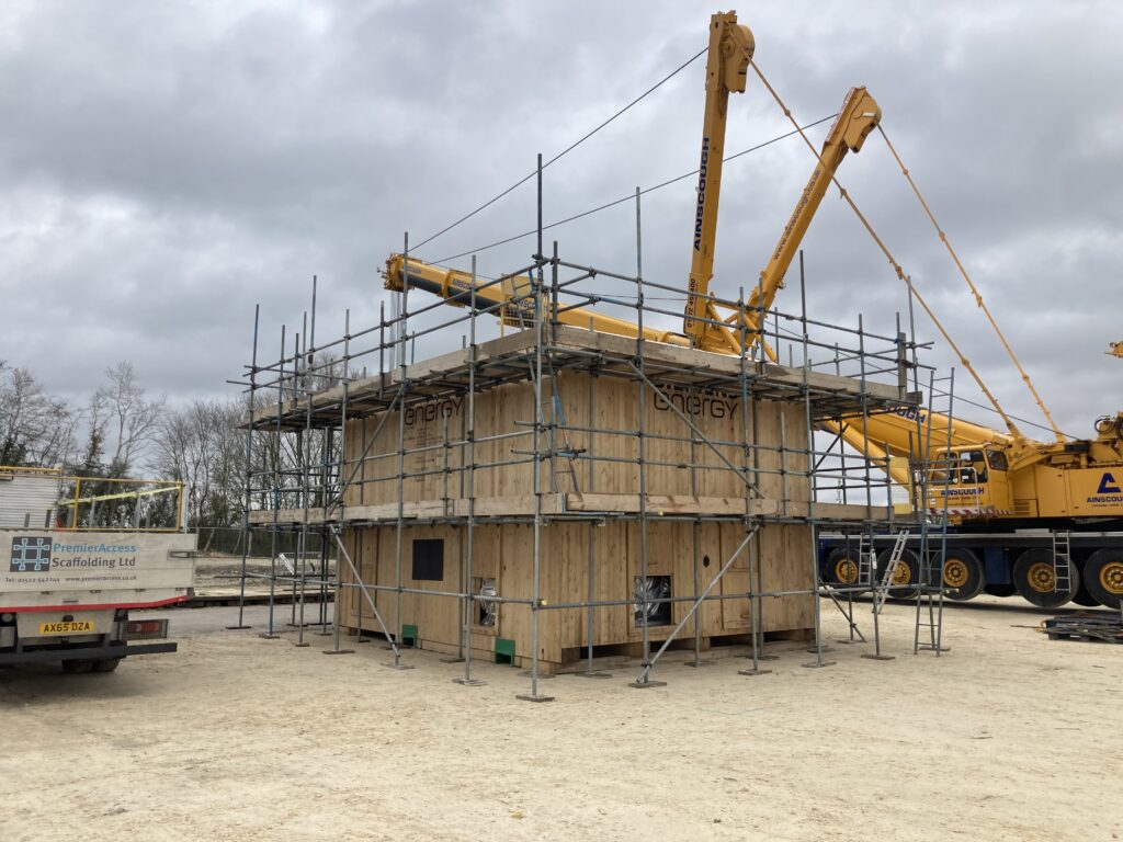 scaffolding surrounding a covered gas compressor on a construction site