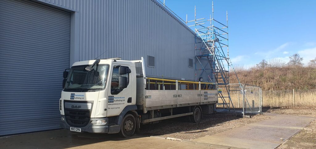 a van parked by some scaffolding equipment for roof access