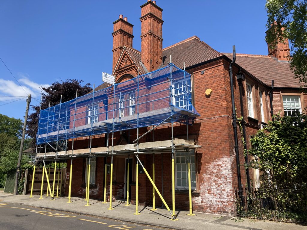 scaffolding on the front of a building by a road