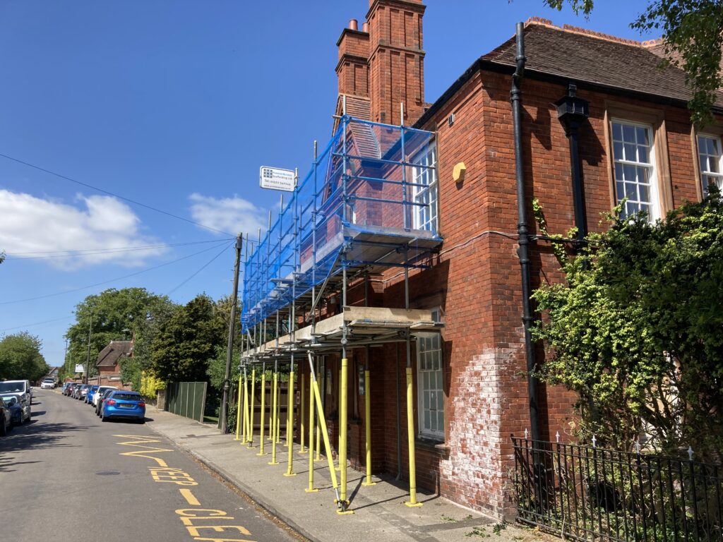 scaffolding on the front of a building by a road