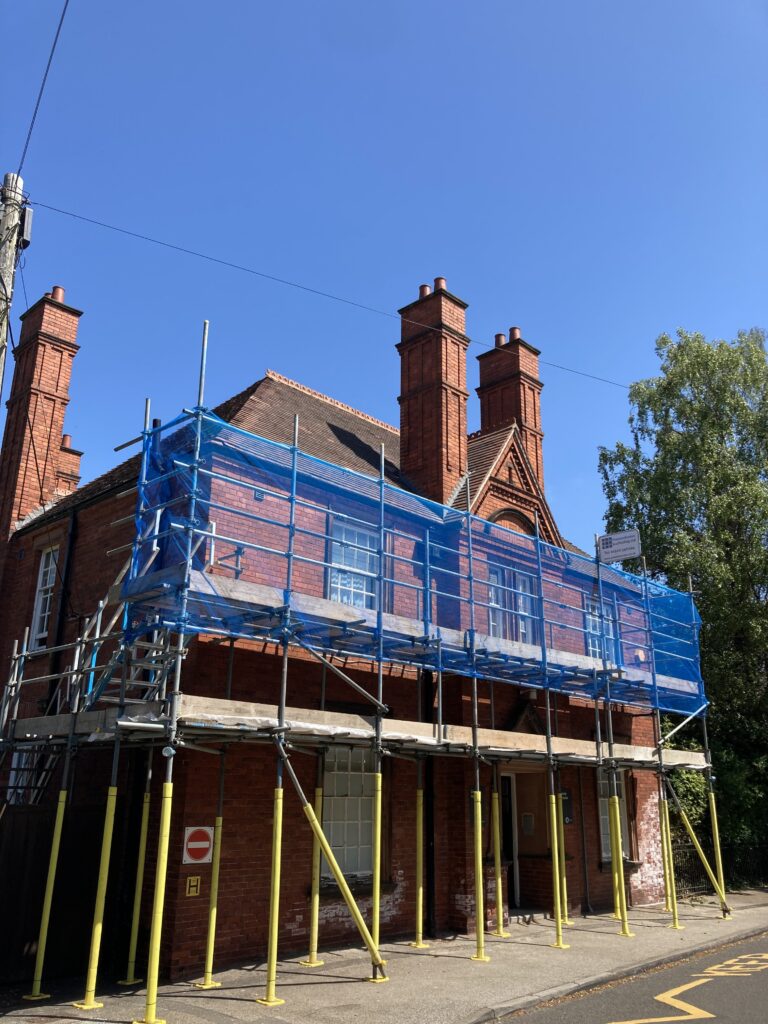scaffolding on the front of a building by a road
