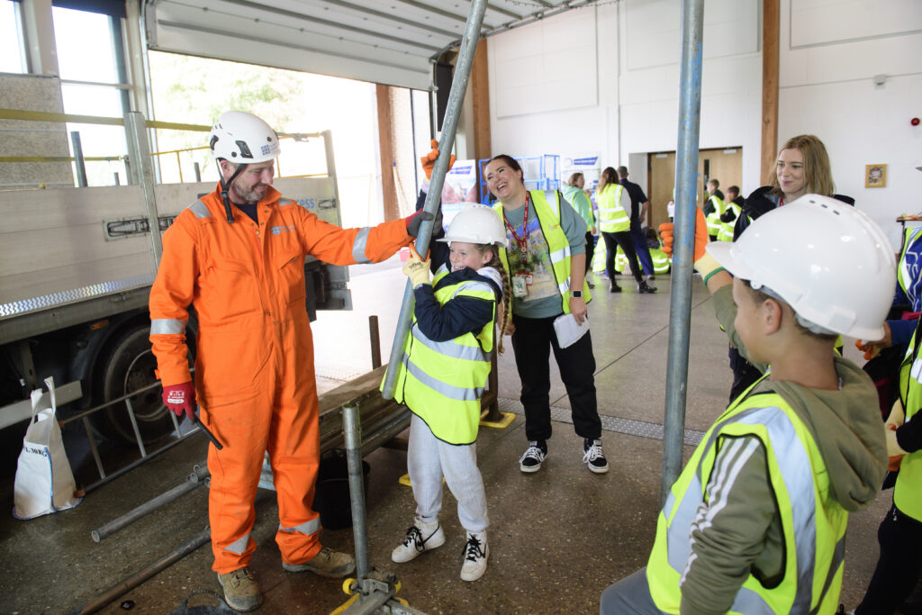 Kids learning how to erect scaffolding equipment