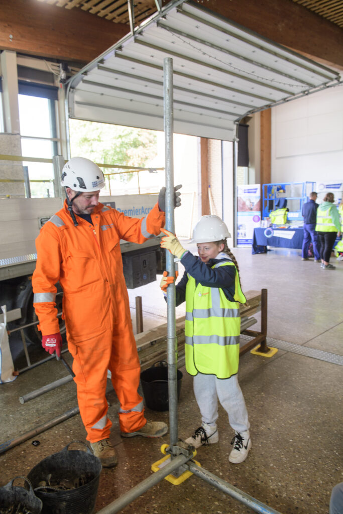Kids learning how to erect scaffolding equipment