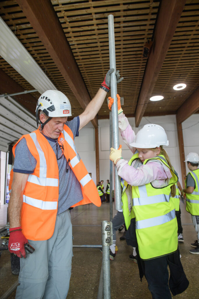 Kids learning how to erect scaffolding equipment