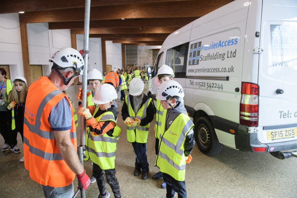 Kids learning how to erect scaffolding equipment