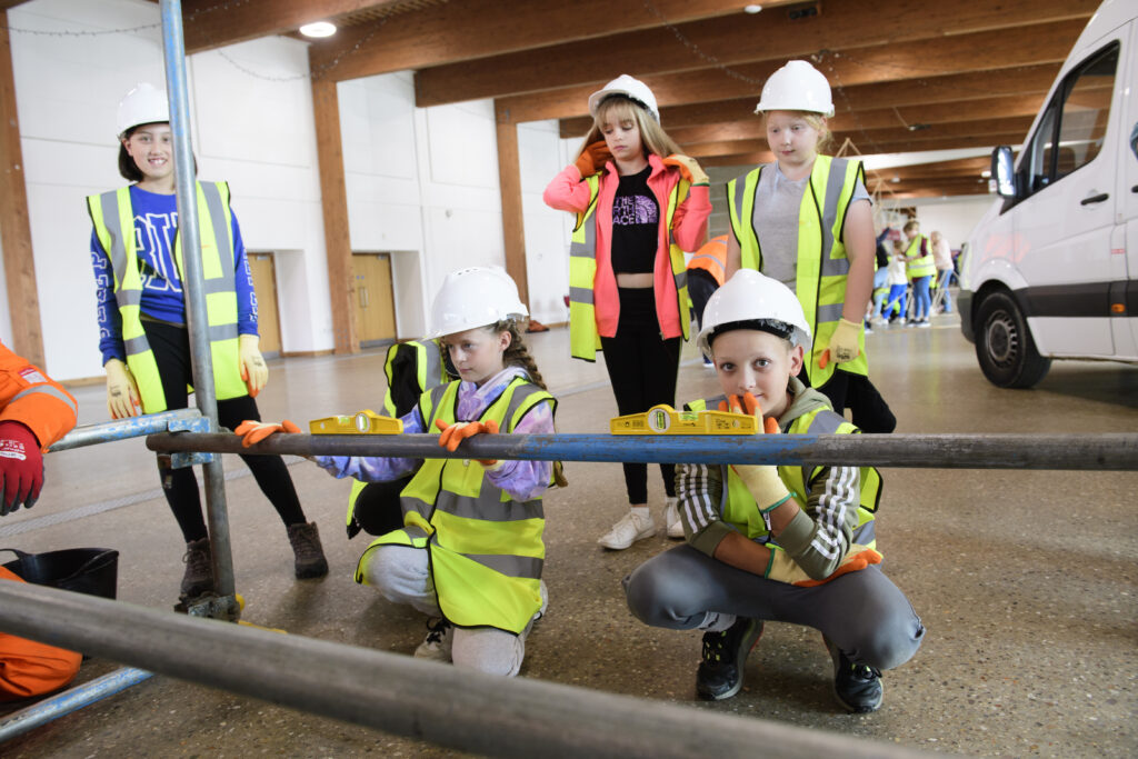 Kids learning how to erect scaffolding equipment
