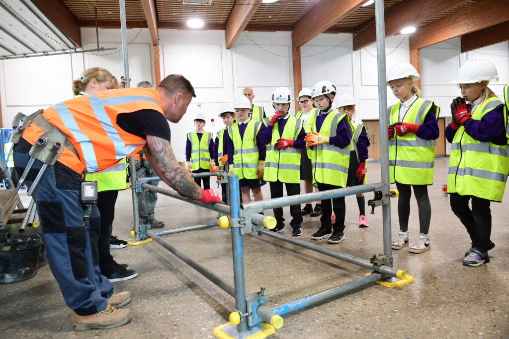 Kids learning how to erect scaffolding equipment