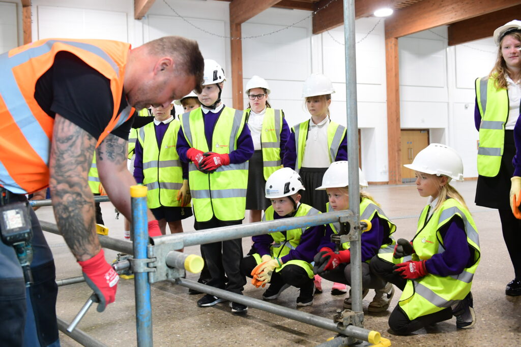 Kids learning how to erect scaffolding equipment
