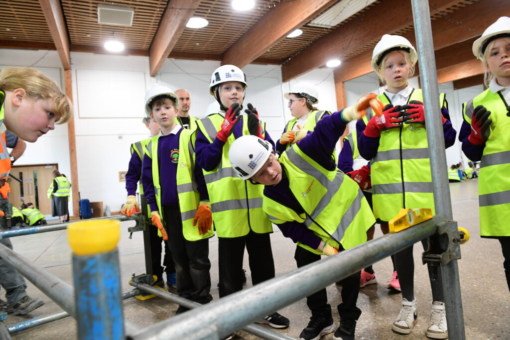 Kids learning how to erect scaffolding equipment