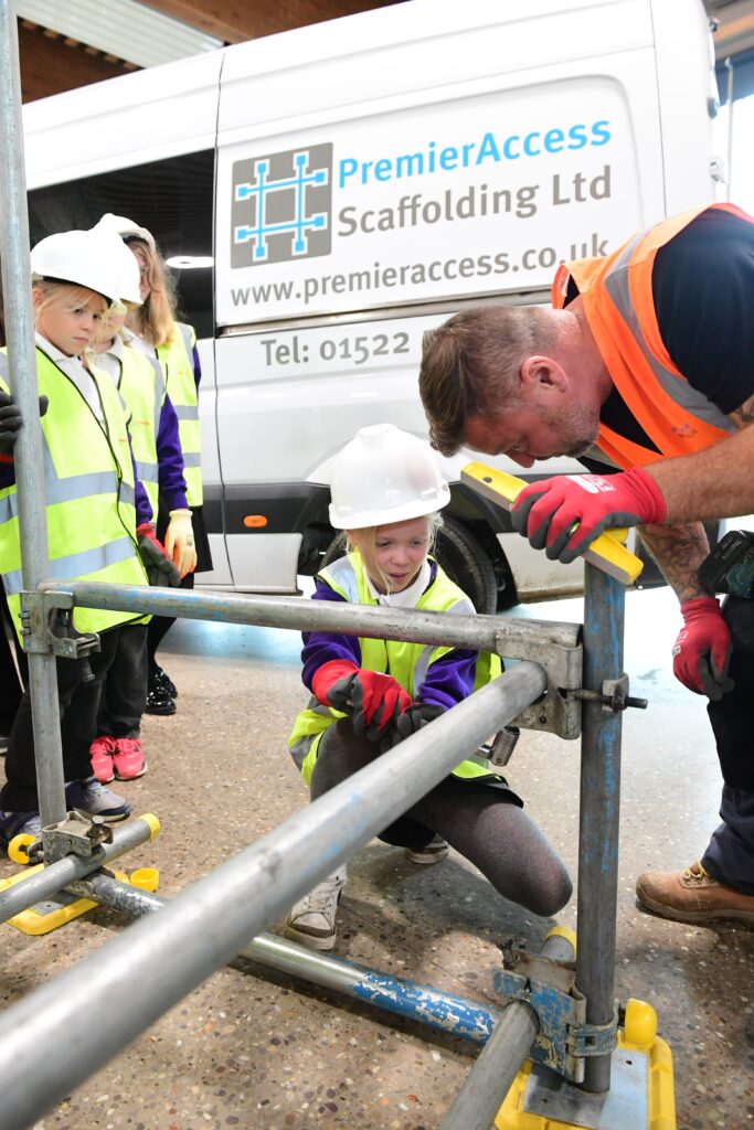 Kids learning how to erect scaffolding equipment