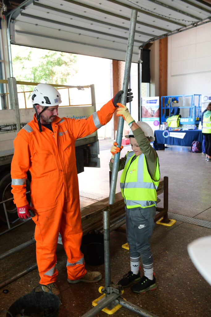 Kids learning how to erect scaffolding equipment