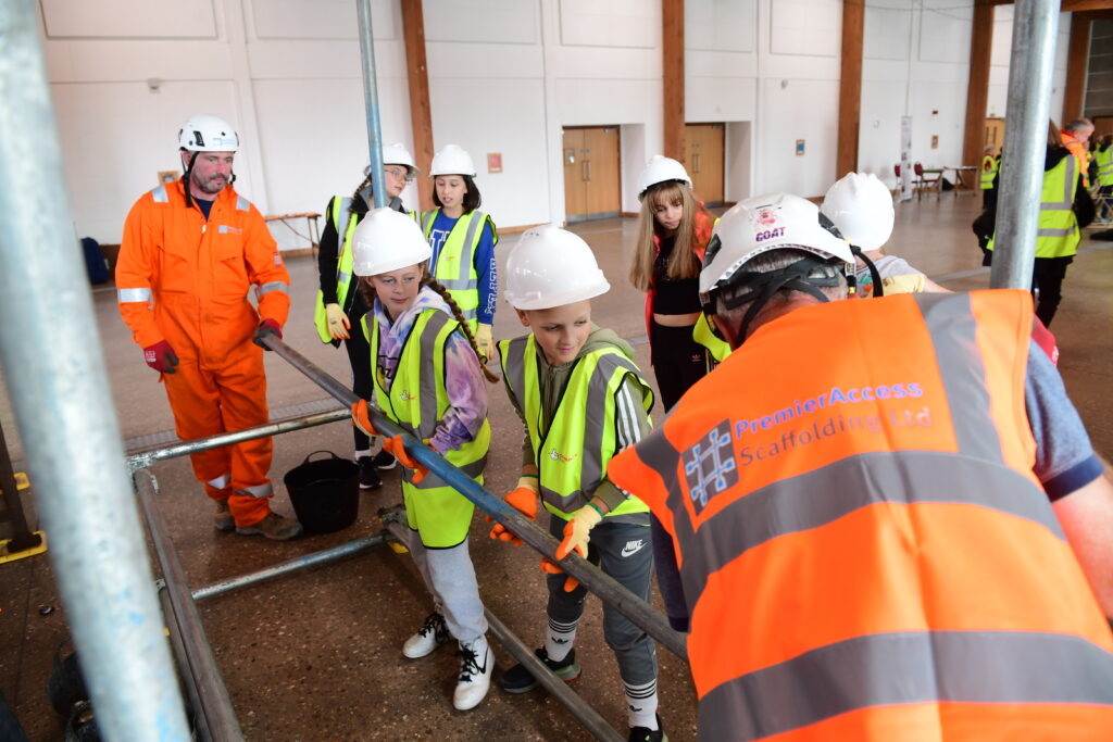 Kids learning how to erect scaffolding equipment