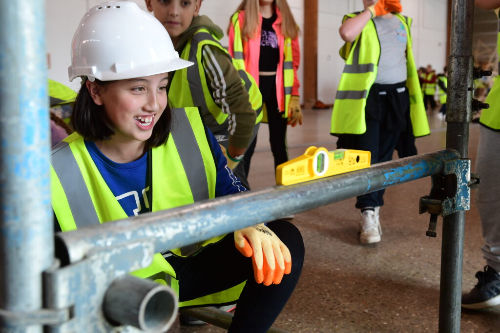 Kids learning how to erect scaffolding equipment